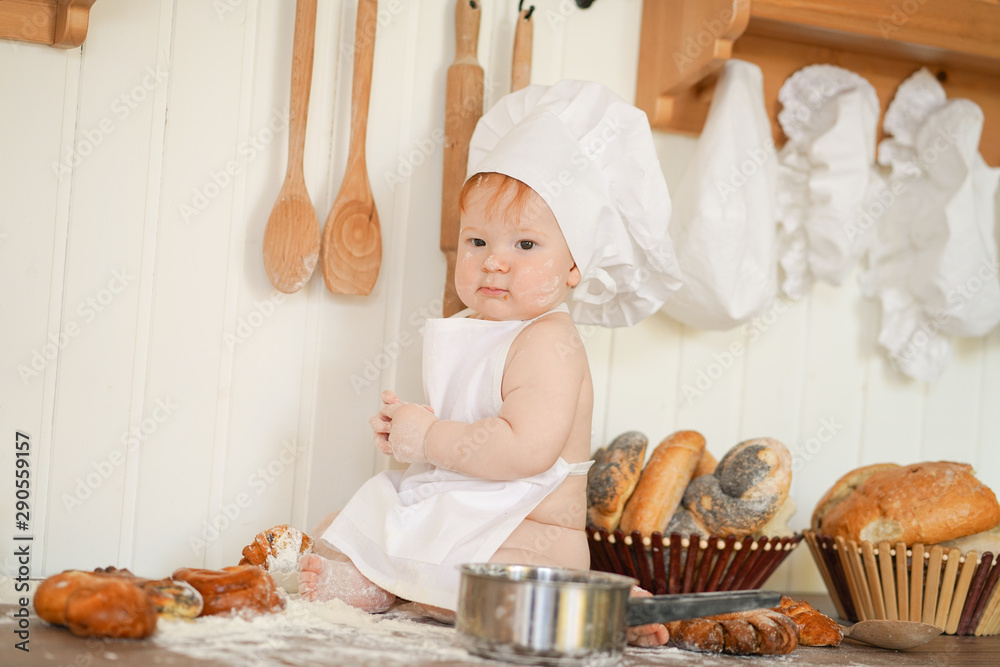 little baker child in chef hat at kitchen table alone little baker child in chef hat at kitchen table alone