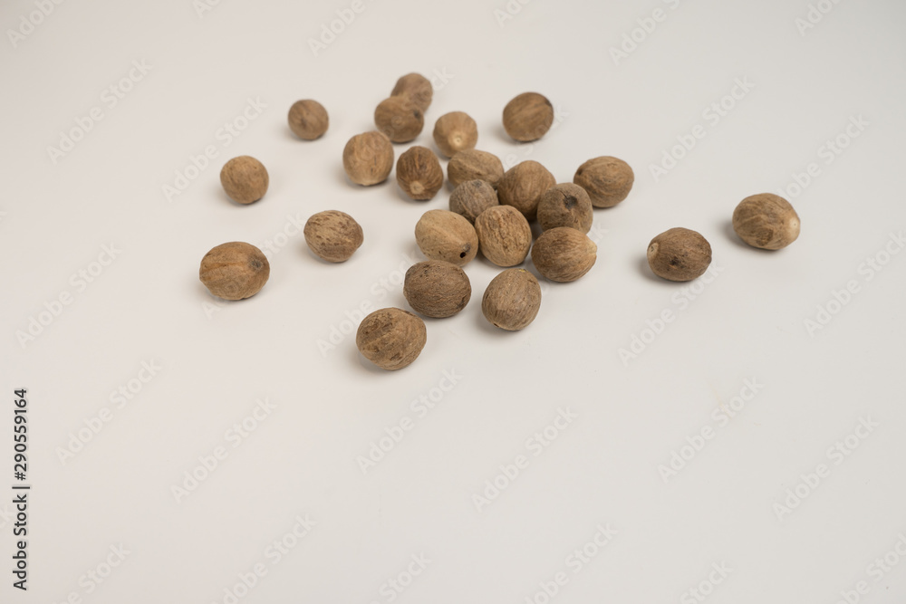 Loose nutmeg on a white plate and plate Loose nutmeg on a white plate and plate