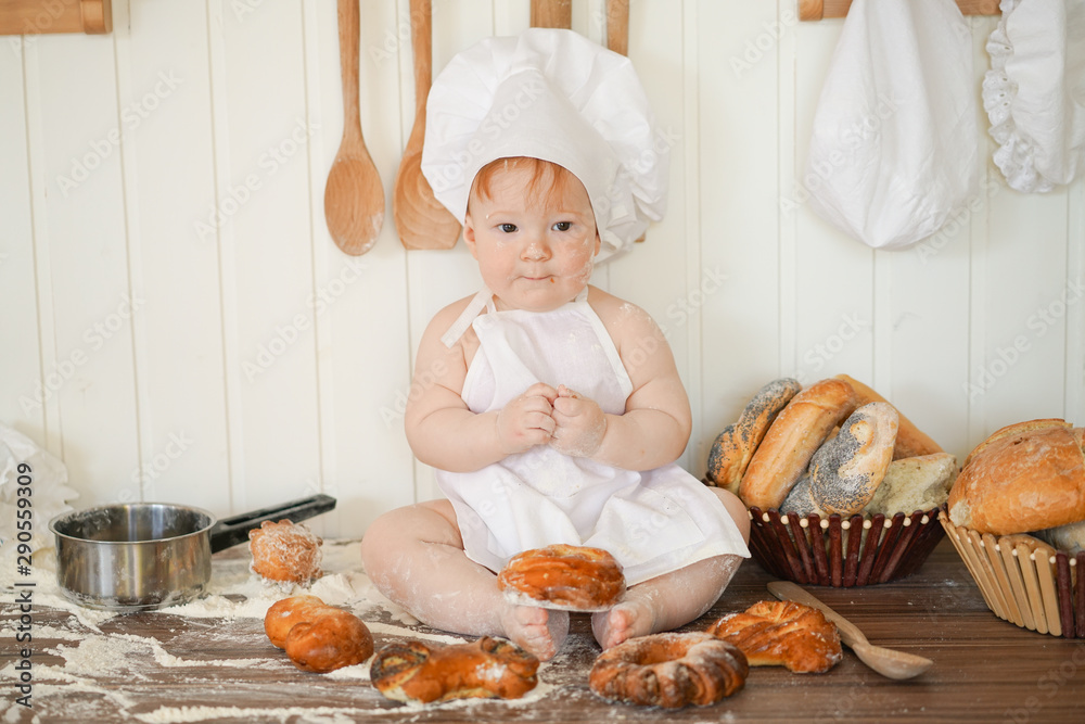 little baker child in chef hat at kitchen table alone little baker child in chef hat at kitchen table alone