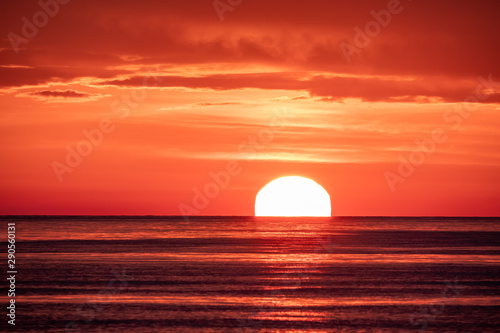 Beautiful red and orange sunset over the sea. The sun goes down over the sea. © Dmitrii Potashkin