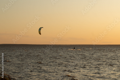 Kite boarding - competition of athletes at sea on a summer evening
