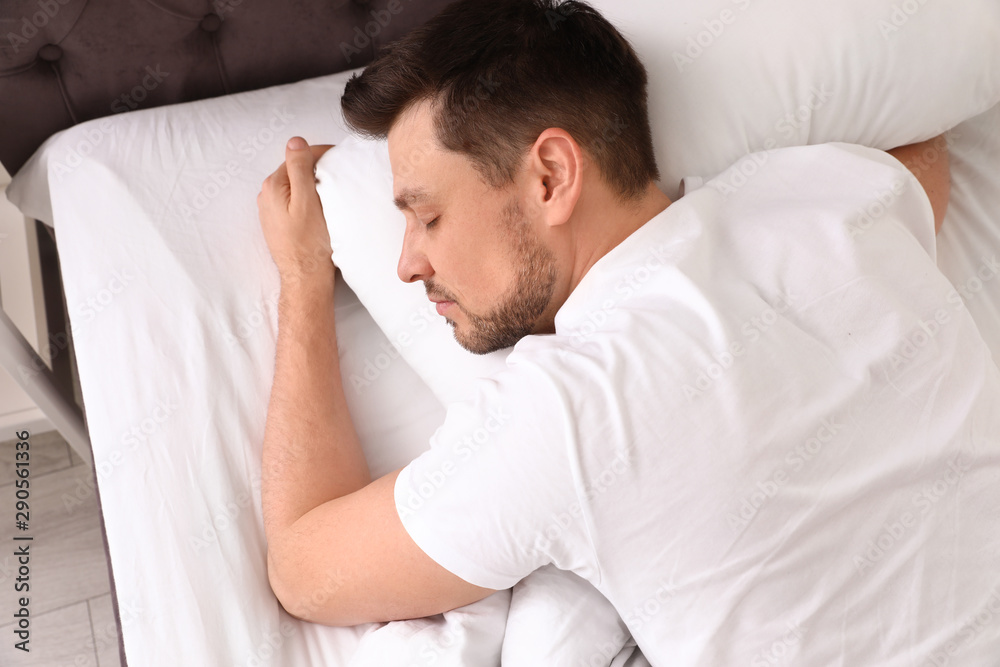 Handsome man sleeping on pillow at home, view from above. Bedtime Handsome man sleeping on pillow at home, view from above. Bedtime