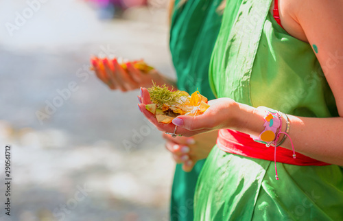 Woman hold traditional hinduist offerings to gods including flowers and aromatic sticks -Pura Tirtha Empul Temple, Indonesia photo