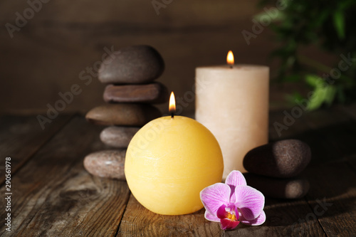 Composition with candles and spa stones on wooden table