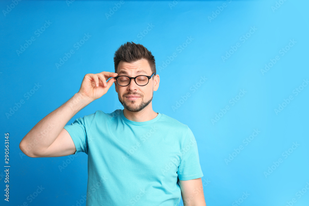 Man with vision problems wearing glasses on blue background, space for text Man with vision problems wearing glasses on blue background, space for text