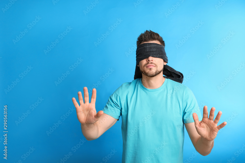 Man with black blindfold on blue background, space for text Man with black blindfold on blue background, space for text
