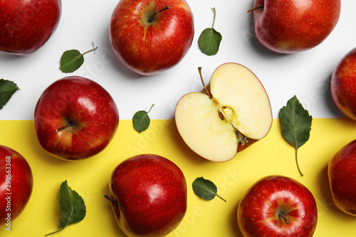 Flat lay composition with ripe juicy red apples and leaves on color background
