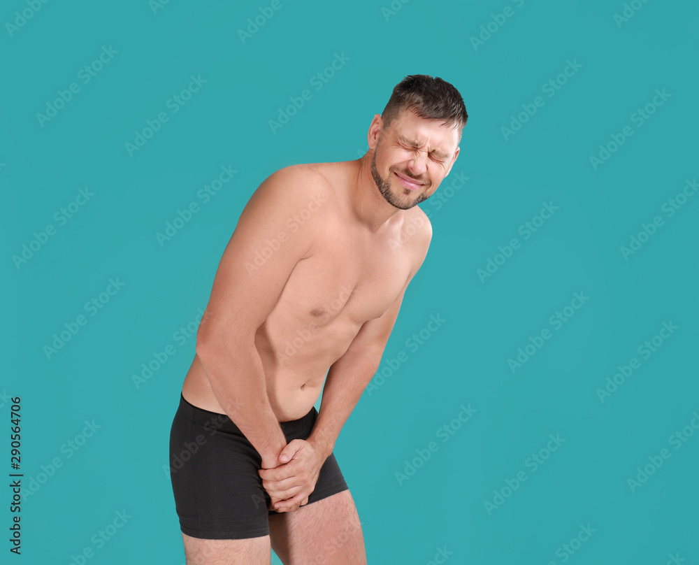 Man suffering from pain on turquoise background. Urology problems