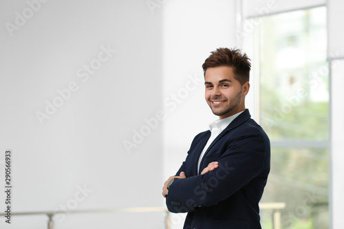 Portrait of handsome young man in elegant suit indoors. Space for text