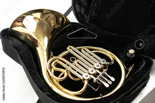 Corno, instrumento musical dorado sobre fondo blanco