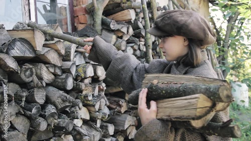 Poor tired girl makes firewood. Preparing for winter