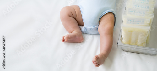 Leg of newborn baby and breast milk frozen in storage plastic bag, Breastfeeding from pumping milk mother