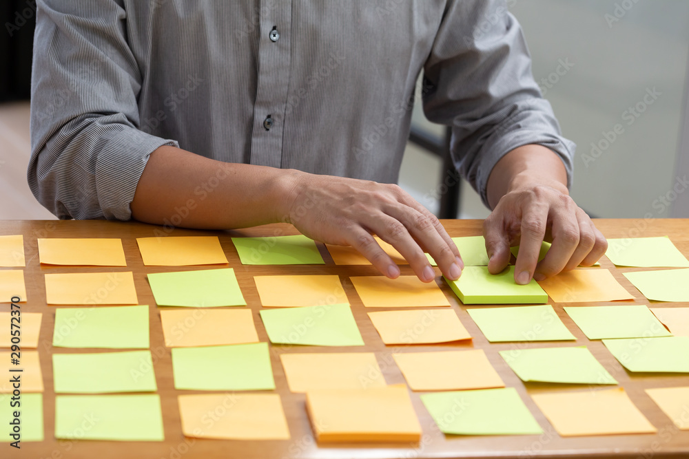 Businessman planning task work with sticky note on table in the office, Scrum board and agile methodology concept Businessman planning task work with sticky note on table in the office, Scrum board and agile methodology concept