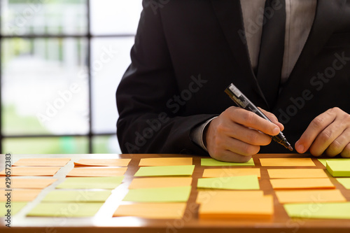 Businessman planning task work with sticky note on table in the office  Scrum board and agile methodology concept