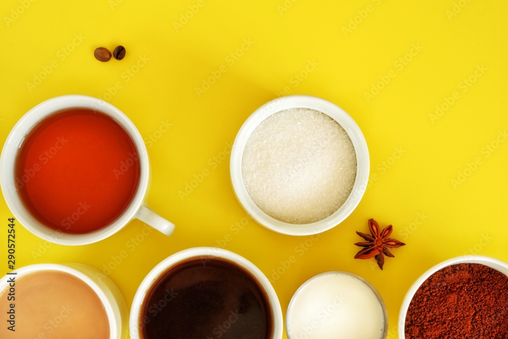 Flat lay composition of various cups of coffee, tea with sugar, cream and star anise on a bright yellow background. Coffee break. Top view.