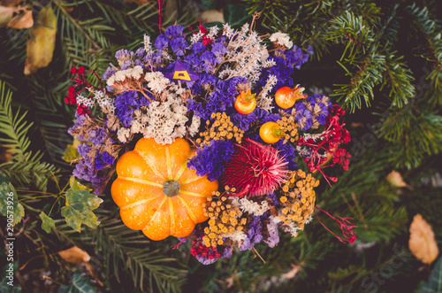 bright floral decoration from dried flowers on grave during All Saints Day in the cemetery photo