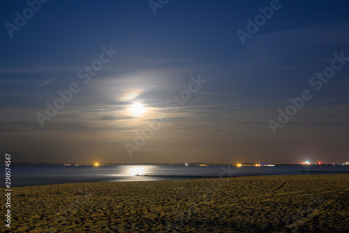 Moonrise at the seaside from Usedom, Germany. In the haze on the horizon you can see lights on the Polish coast.