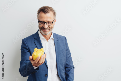 Fotografía Successful businessman looking at his piggy bank