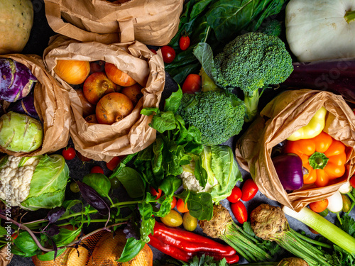 Garden produce and harvested vegetable. Fresh farm vegetables Zero waste and eco friendly shopping with vegetables and fruits in paper bags top view. Plastic free and reuse concept.