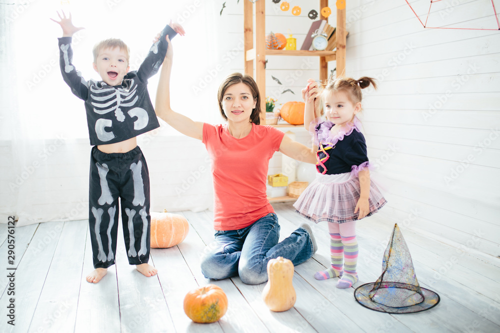 Fototapeta premium Happy family of mother and children prepare for Halloween in decorate the home