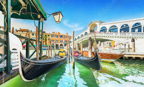 Panoramic view of Gondolas and boat at their moorings against famous Rialto Bridge at Grand Canal in Venice, Italy, Europe