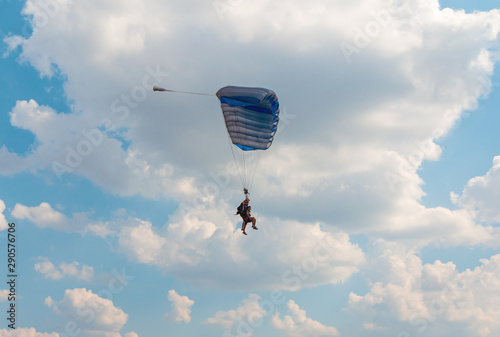Two men flying in the blue sky using parachute