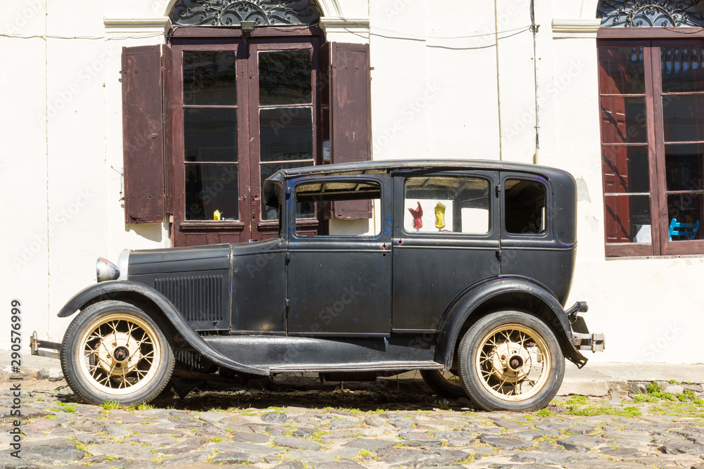 Fototapeta premium Black and obsolete car on one of the cobblestone streets, in the city of Colonia del Sacramento, Uruguay. It is one of the oldest cities in Uruguay.