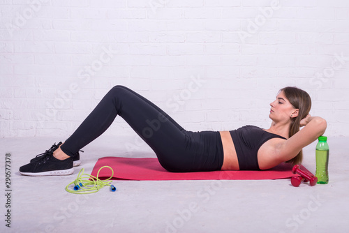 Young slim girl doing fitness lying on the mat.