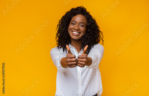 Happy young black woman showing thumbs up photo