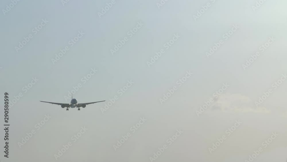Close up shot of silhouette big wide-body civil jet airplane is landing in airport in day time Close up shot of silhouette big wide-body civil jet airplane is landing in airport in day time