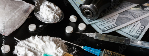 Quadro su tela drug is a white powder, tablets, syringes sprinkled on a black table