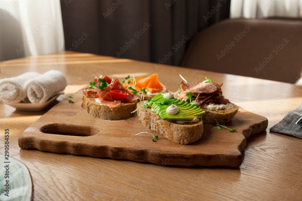 Delicious crispy sandwiches on a wooden tray