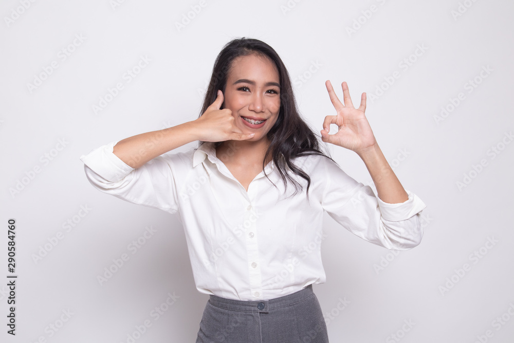 Young Asian woman show with phone gesture and OK sign. Young Asian woman show with phone gesture and OK sign.