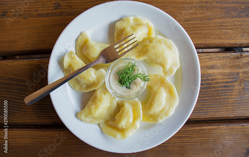 Dumplings on a white plate with sour cream. - Traditional Ukrainian food.