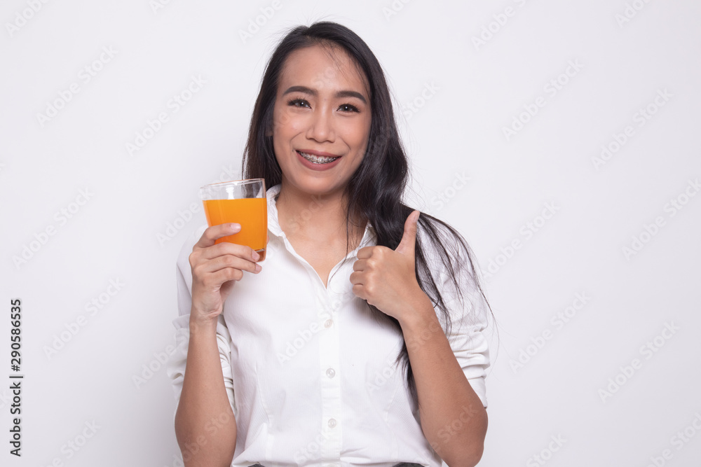 Young Asian woman thumbs up drink orange juice. Young Asian woman thumbs up drink orange juice.