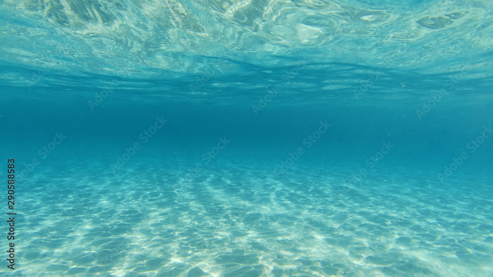 Underwater photo of tropical exotic turquoise sandy beach with crystal clear sea