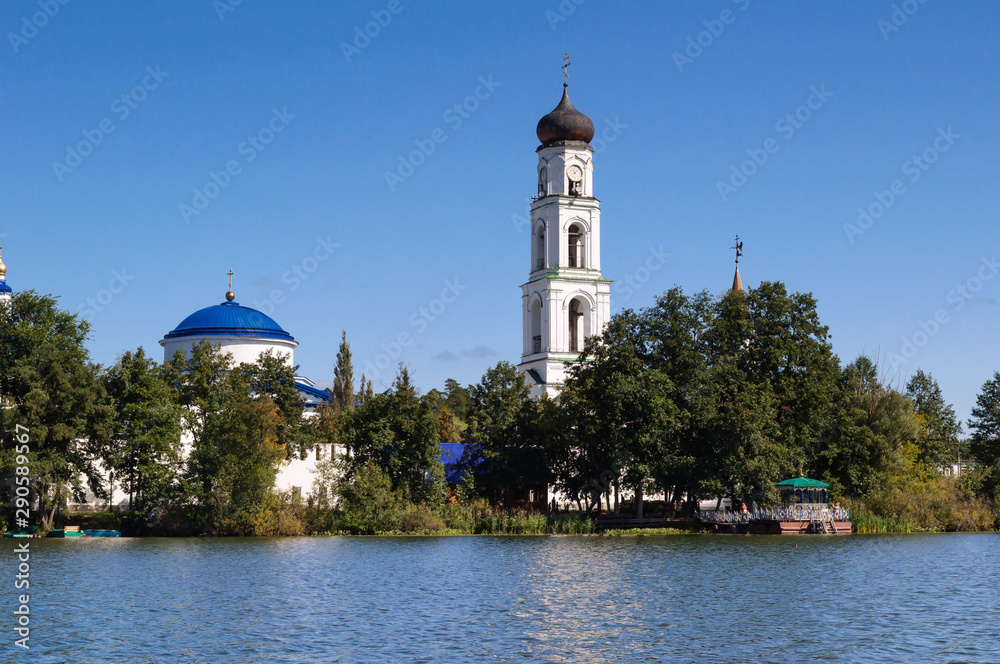 View from the lake to the bell tower of Raif monastery, Russia.