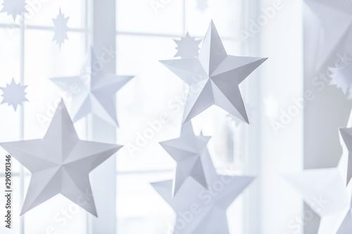 Fototapeta Naklejka Na Ścianę i Meble -  New year and Christmas concept, decorative paper stars hanging beside the window