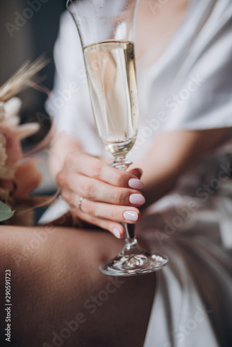 the bride is holding a glass of champagne and a bouquet of flowers