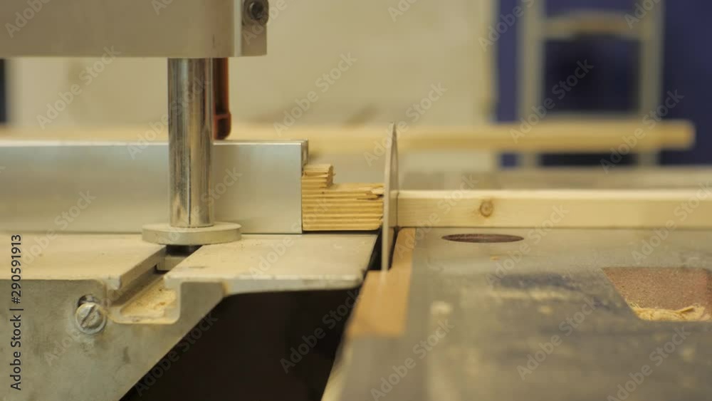 Worker in a carpentry workshop sawing boards on a machine Worker in a carpentry workshop sawing boards on a machine