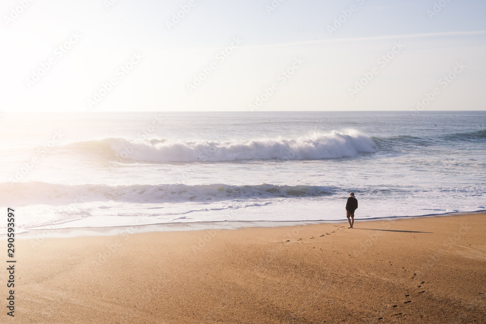 Man standing on the ocean shore in the sunset light Man standing on the ocean shore in the sunset light