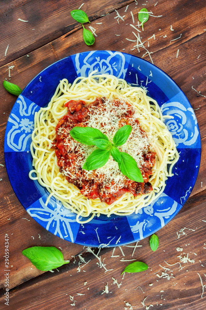 Spaghetti with cheese tomato sauce on wooden table.