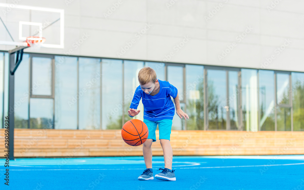 Obraz premium Adorable child playing the basketball in the basket field