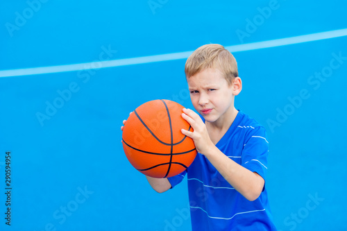 Adorable child playing the basketball in the basket field © Augustas Cetkauskas