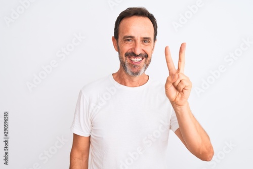 Middle age handsome man wearing casual t-shirt standing over isolated white background showing and pointing up with fingers number two while smiling confident and happy.
