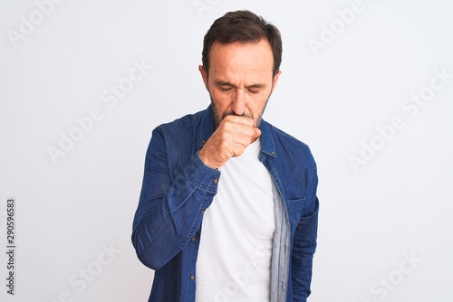 Middle age handsome man wearing blue denim shirt standing over isolated white background feeling unwell and coughing as symptom for cold or bronchitis. Healthcare concept.