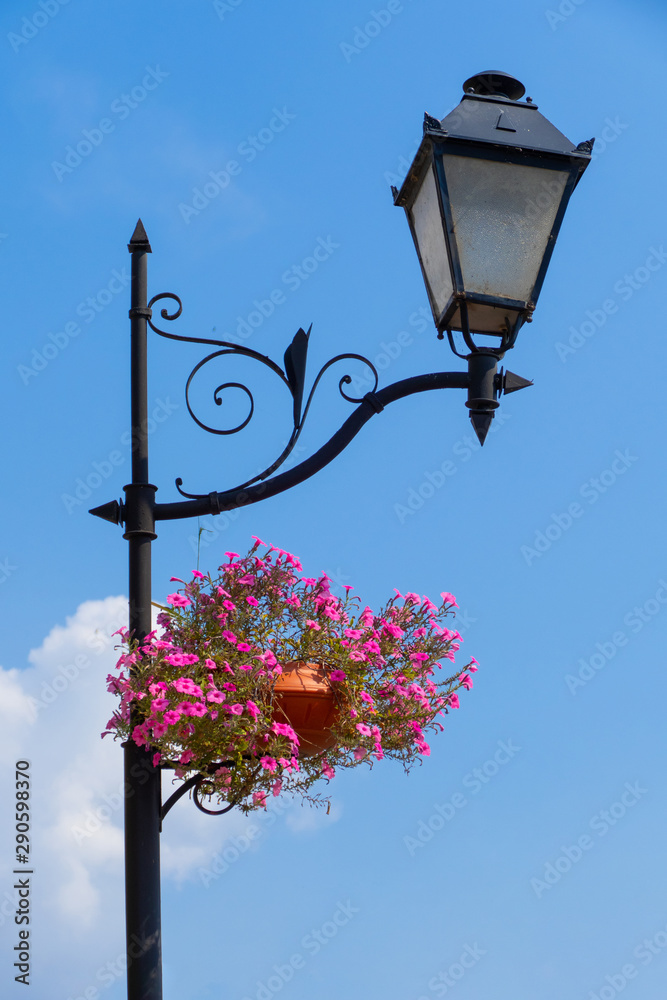 Old street lamp on the background of blue sky. Street light with ornamental  flowerpot foto de Stock | Adobe Stock