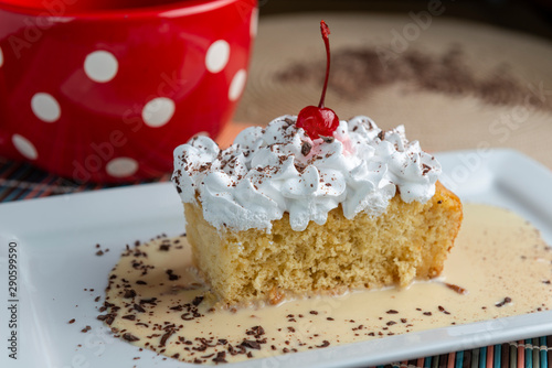 Three milk cake, tres leches cake with cherry and chocolate. Traditional dessert of Latin America.