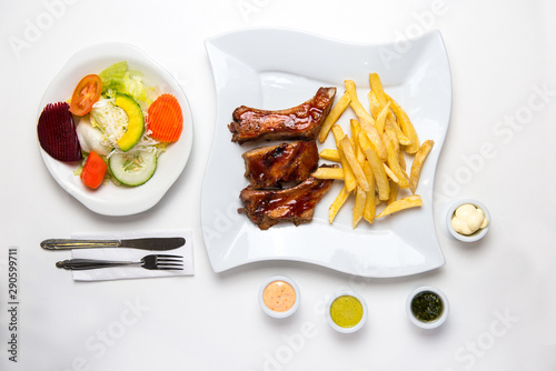 Barbecue ribs with french fries, salad and cream. BBQ. Top view.