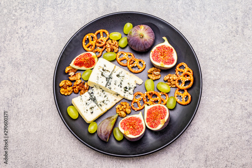 Cheese plate with blue cheese, walnuts, figs, grapes, pretzels